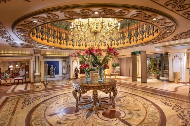 Atrium chandelier above a round table with flower arrangement