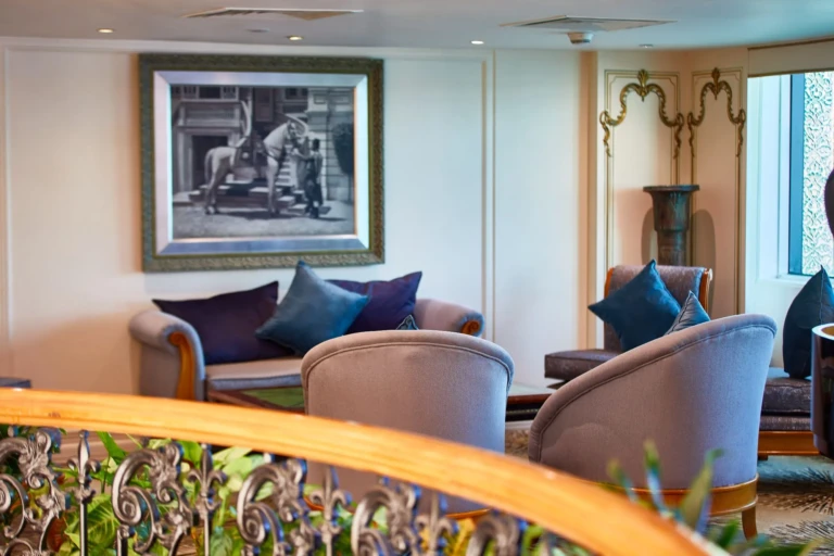 Lounge sofas with blue cushions below framed artwork