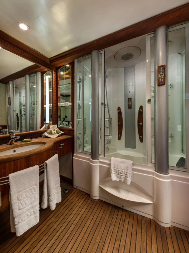 Bathroom with glass shower cabin and teak decking floor