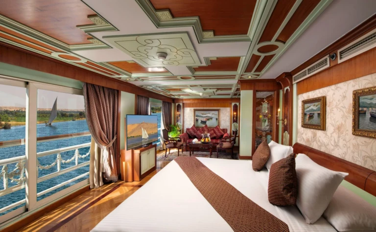 Suite with king bed and sofa facing Nile view balcony doors