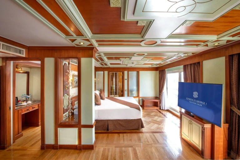 Suite bedroom with coffered ceiling, wall TV and wooden floor