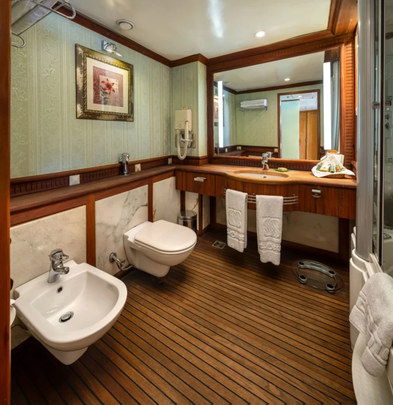Cabin bathroom with teak floor, framed art and twin towels