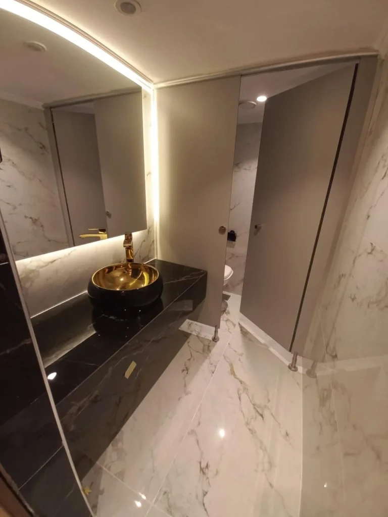 Public restroom with gold basin and marble walls, Sonesta Star Goddess