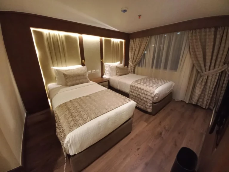 Twin cabin with patterned bedspreads and curtained window, Sonesta Star Goddess