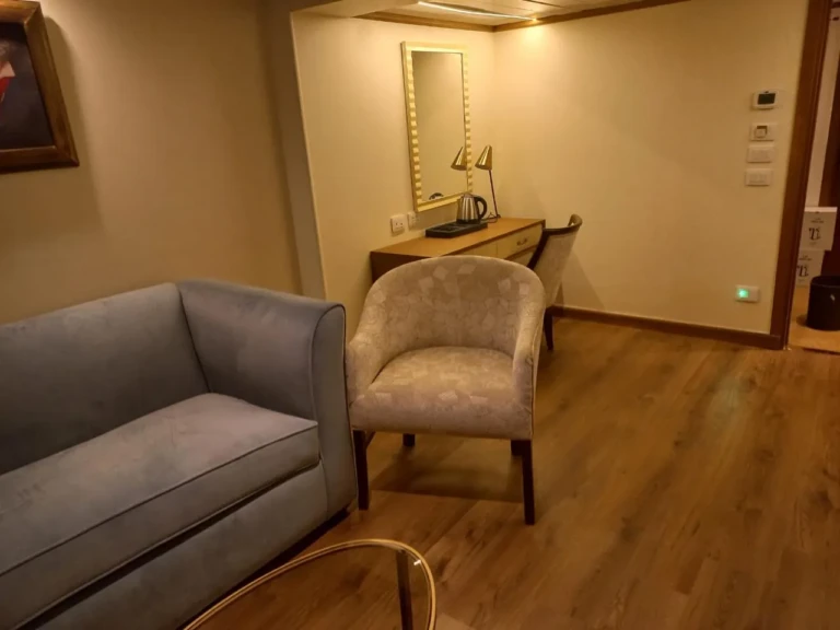 Suite sitting area with sofa, armchair and vanity desk on the Sonesta Star Goddess