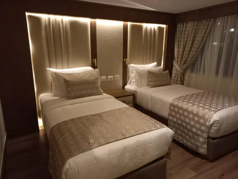 Twin beds with backlit headboard panel in a Sonesta Star Goddess cabin