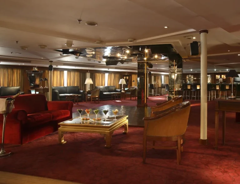 Bar lounge with red sofas and carpet on the Sonesta Star Goddess