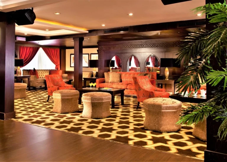 Steigenberger Legacy lounge with orange armchairs and patterned carpet