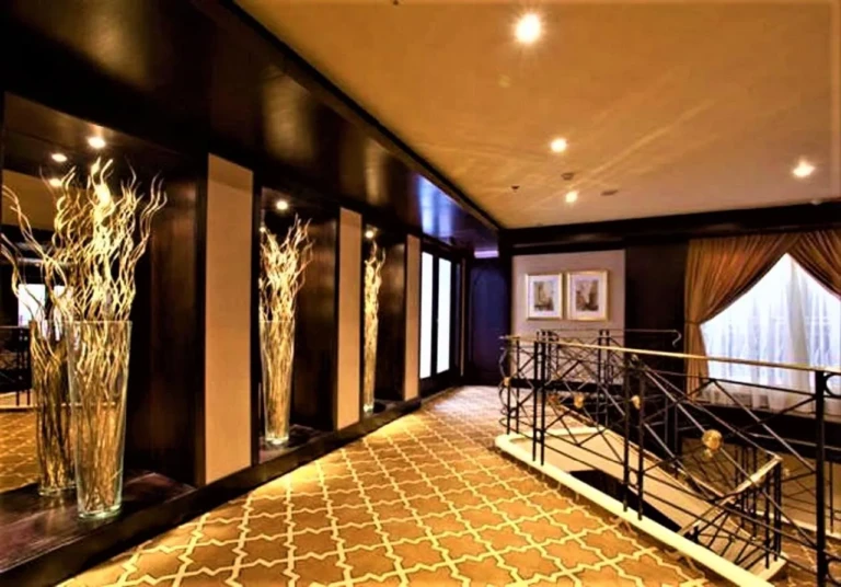 Corridor with decorative branch vases and staircase railing