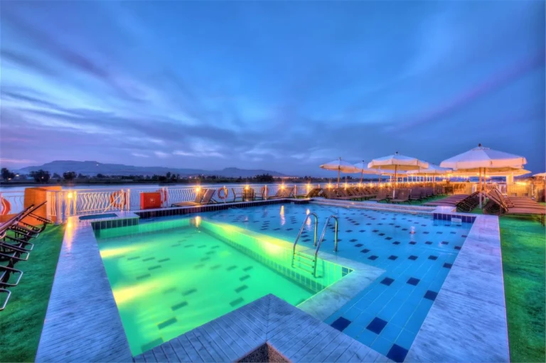 Illuminated pool and parasols at dusk on the Steigenberger Legacy
