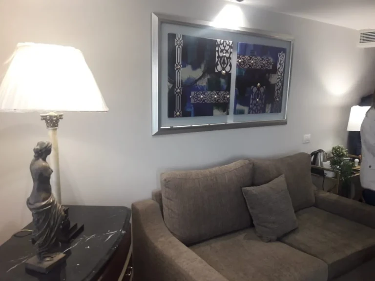 Grey sofa under framed artwork beside a table lamp on the Sun Goddess