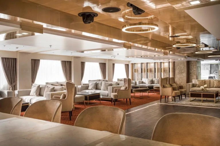 Lounge armchairs under ring ceiling lights, side view, on the Sun Goddess