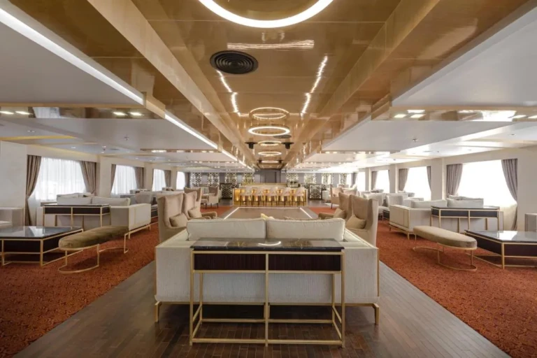Long lounge with white sofas and red carpet on the Sun Goddess