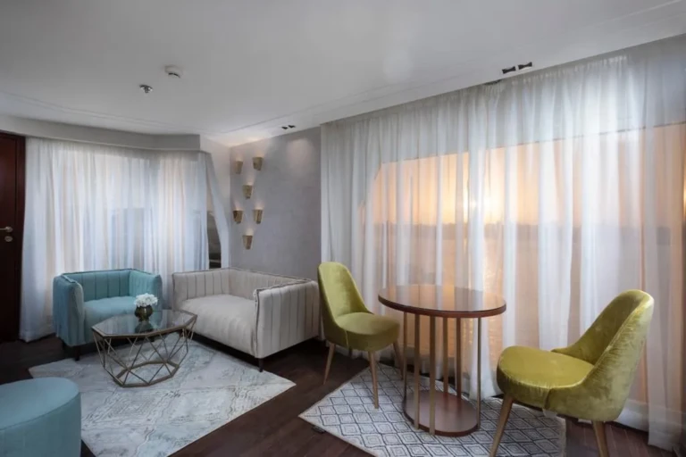 Suite lounge with lime armchairs and teal sofa on the Sun Goddess