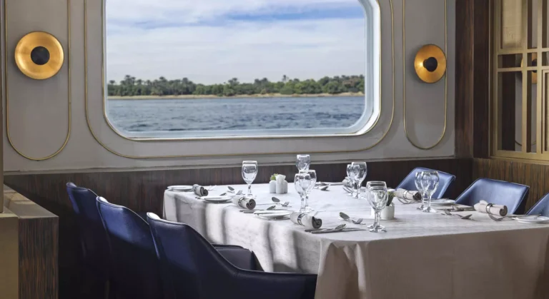Dining table set beside a round-cornered river window on the Tulip