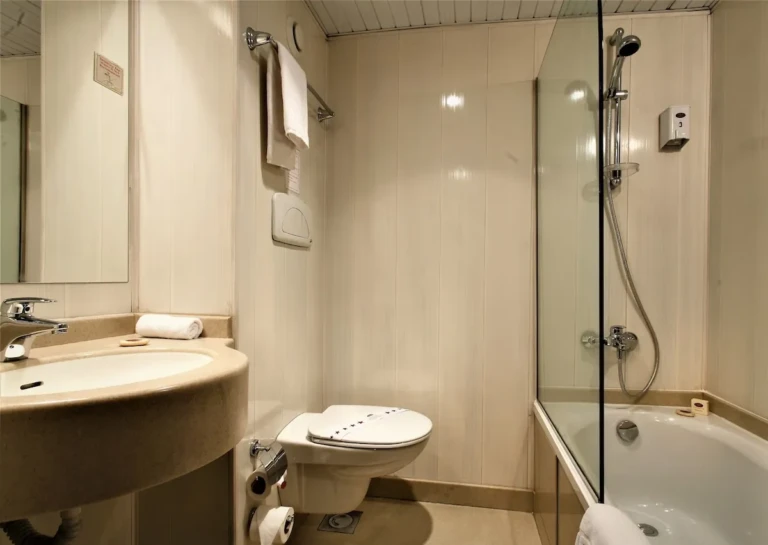 Bathroom with bathtub, glass screen and sink