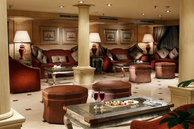 Lounge with red sofas, ottomans and table lamps