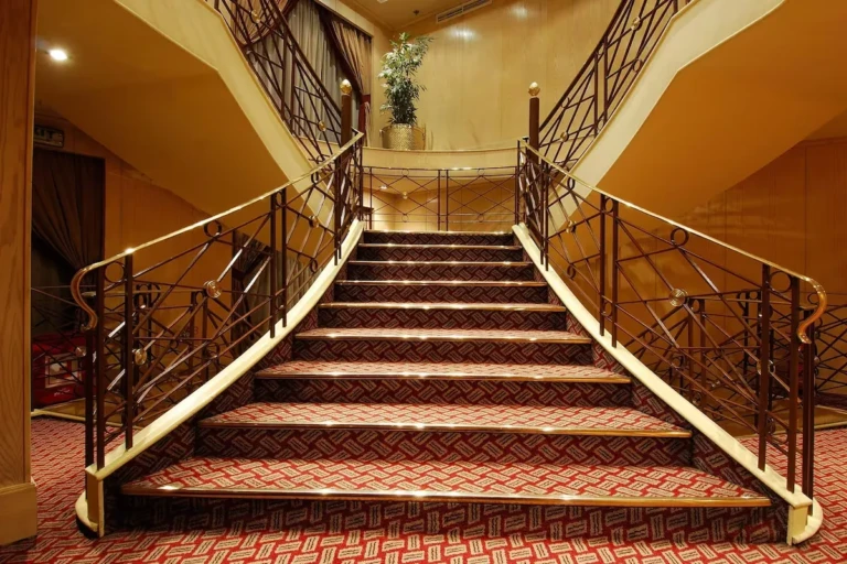 Staircase with wrought-iron railings and red carpet