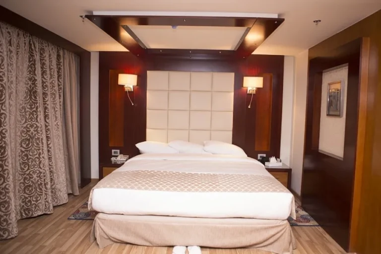 Double bed with tiled headboard and wall lamps, Blue Shadow cabin