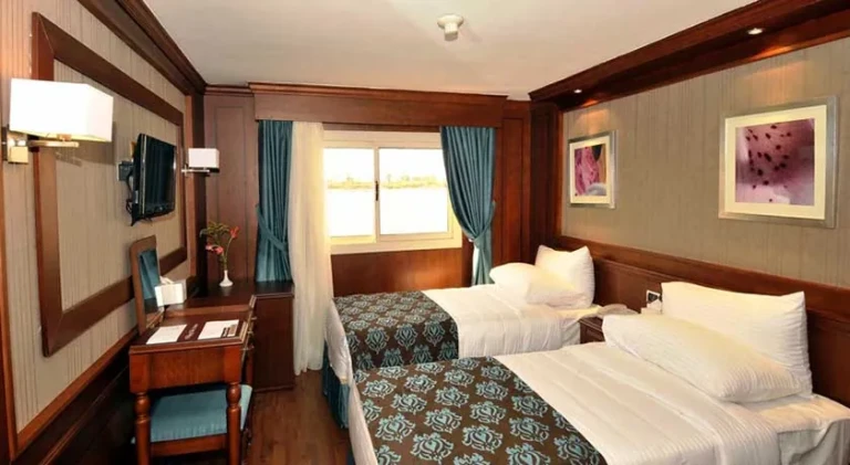 Twin cabin with wood panelling and writing desk on the Farida