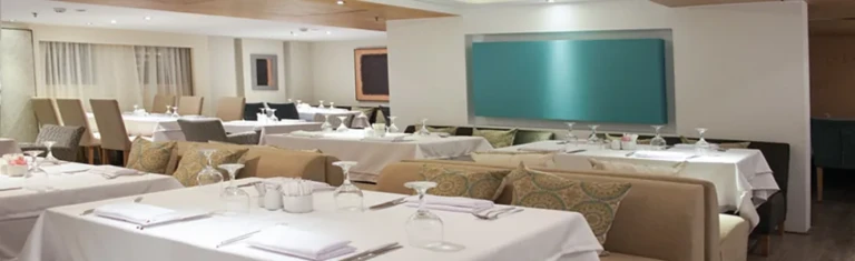 Farida restaurant with white tablecloths and beige booths