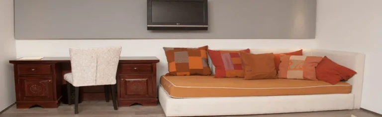 Cabin daybed with orange cushions and desk on the Farida