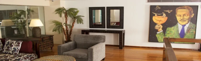 Farida lounge with armchair, potted palm and wall painting