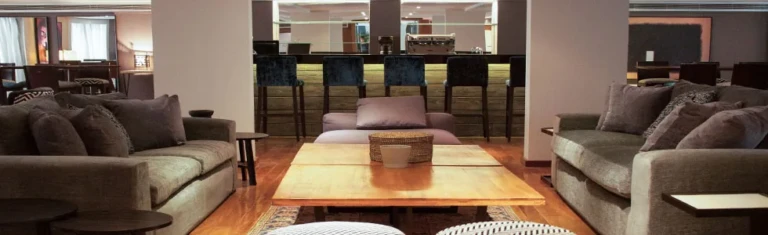 Lounge sofas around a low table with bar behind on the Farida