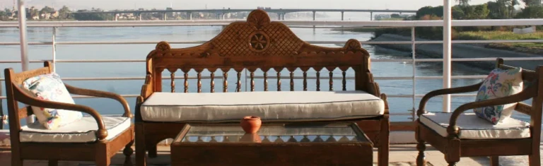 Carved wooden bench and armchairs on the Farida deck