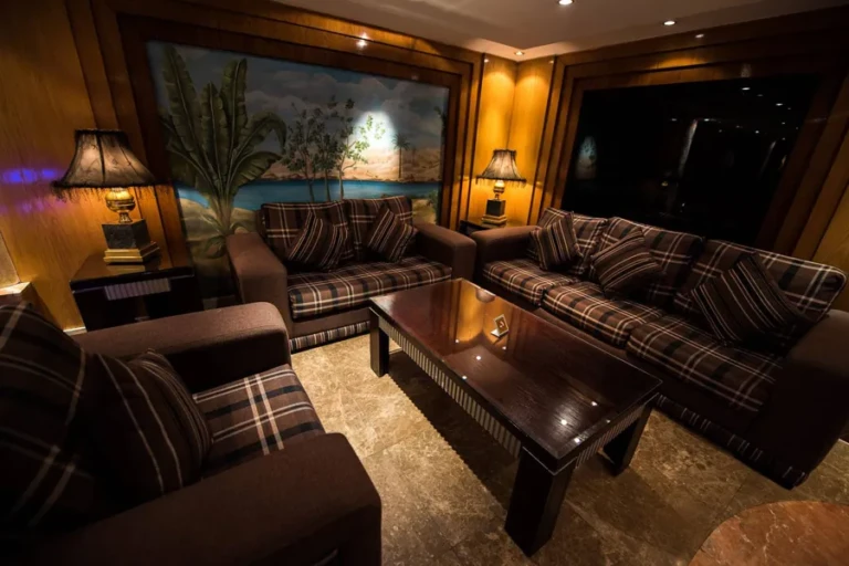 Plaid sofas around a coffee table with palm mural on Royal La Terrasse