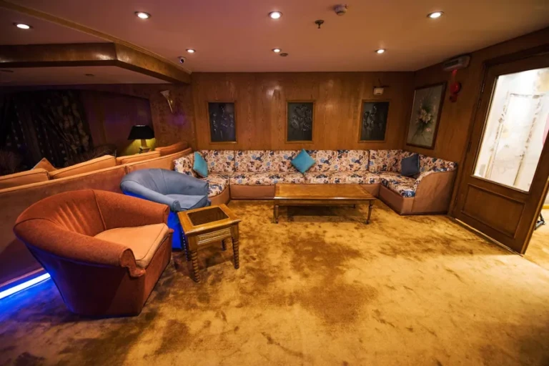 Lounge with wood-panelled walls and floral sofa on Royal La Terrasse