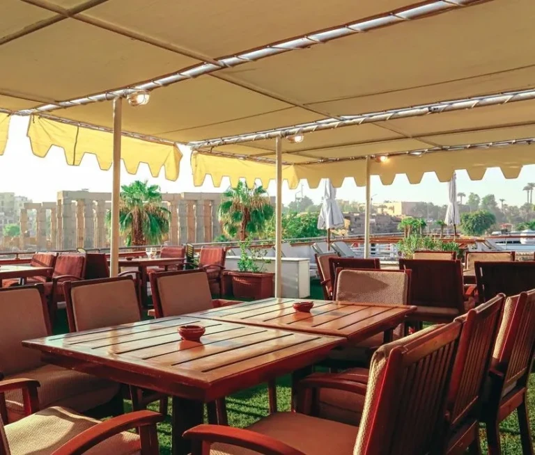 Awning-covered deck tables facing temple ruins on the MS Salacia