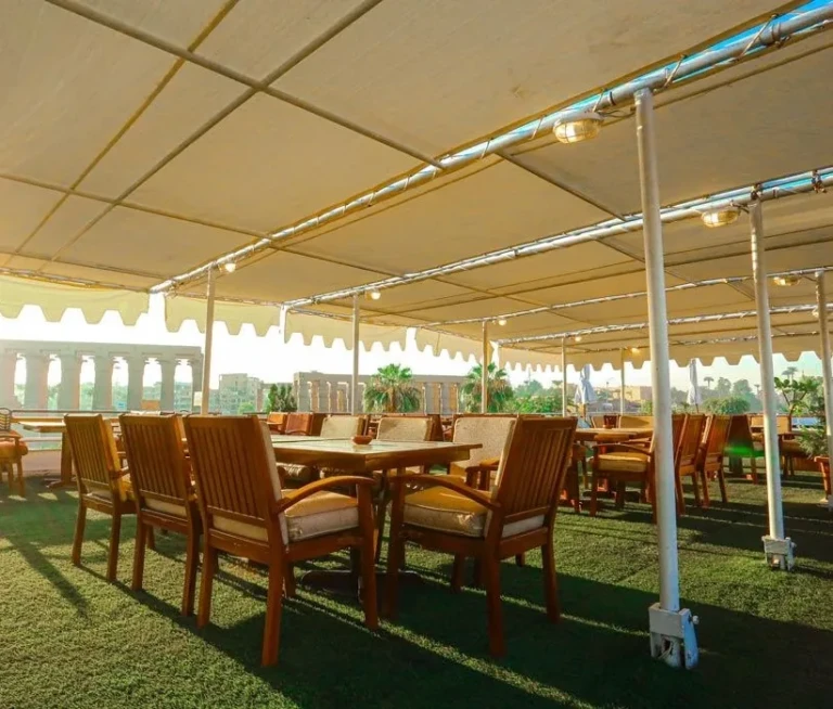 Shaded deck dining tables with wooden chairs on the MS Salacia
