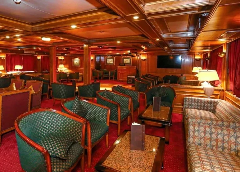 MS Salacia lounge with green armchairs and red carpet