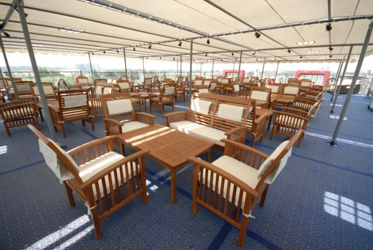 Shaded deck with wooden armchairs and tables