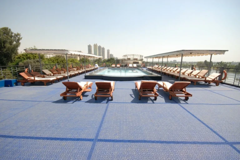 Sun loungers on blue deck facing the pool