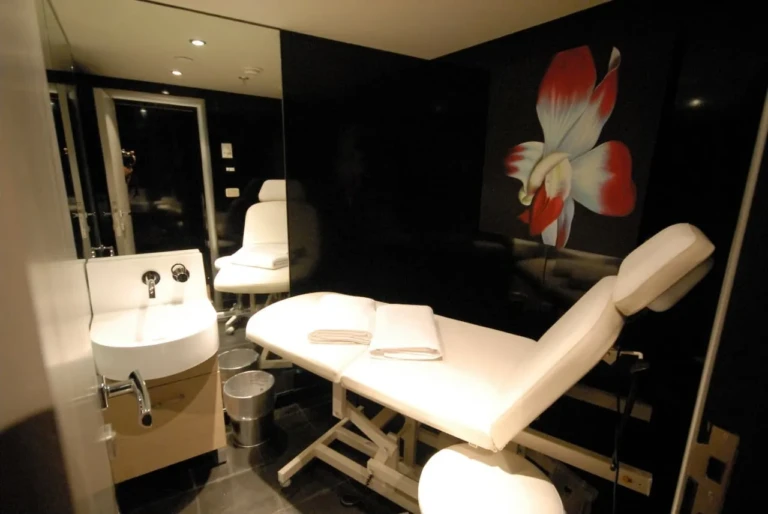 Spa treatment chair and sink beside flower artwork