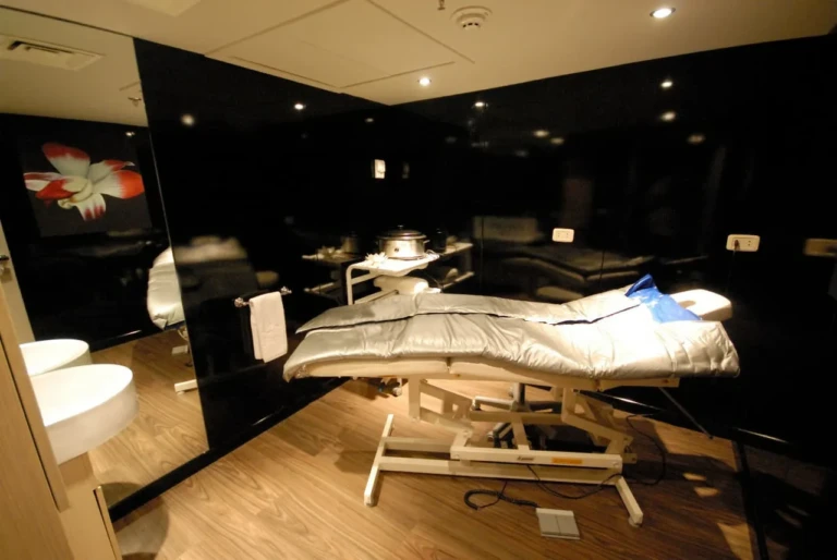 Spa treatment bed in a black-walled room