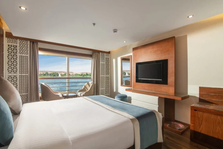 Bed facing a wall TV and Nile window in a Nile Capital cabin