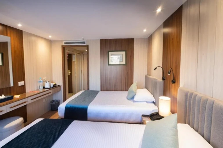Two single beds with bedside lamps in a Renaissance cabin