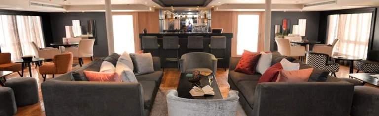 Salima lounge with grey sofas and bar in the background