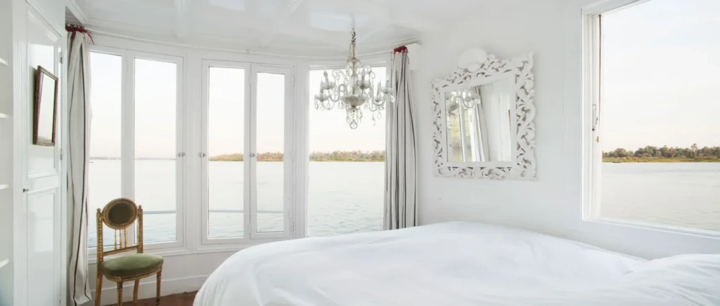 Bright cabin on a Nour El Nil dahabiya with windows over the Nile