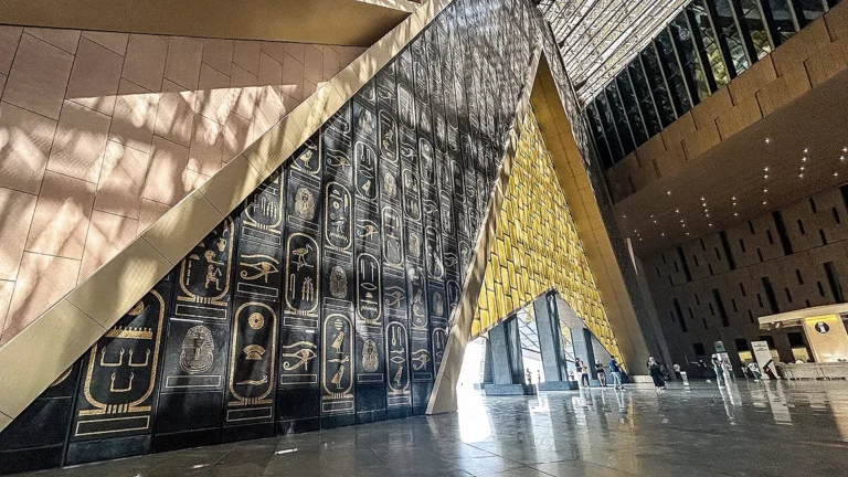 Hieroglyph-covered wall and glass atrium inside the Grand Egyptian Museum