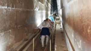 Visitor climbing the ascending passage inside the Great Pyramid
