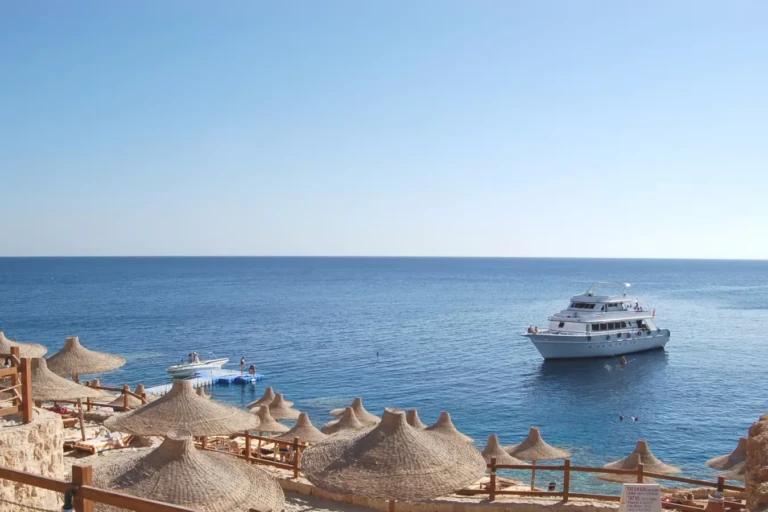 Coastline with thatched beach umbrellas and moored boats