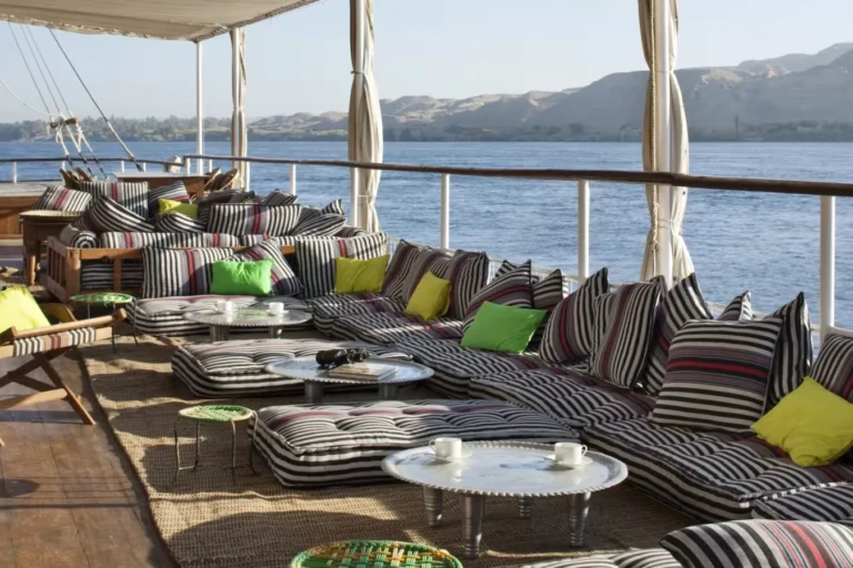 Boat deck lounge with striped sofas and cushions by the Nile