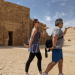 Delta Tours Egypt guests at the Saqqara complex with the Step Pyramid of Djoser behind them